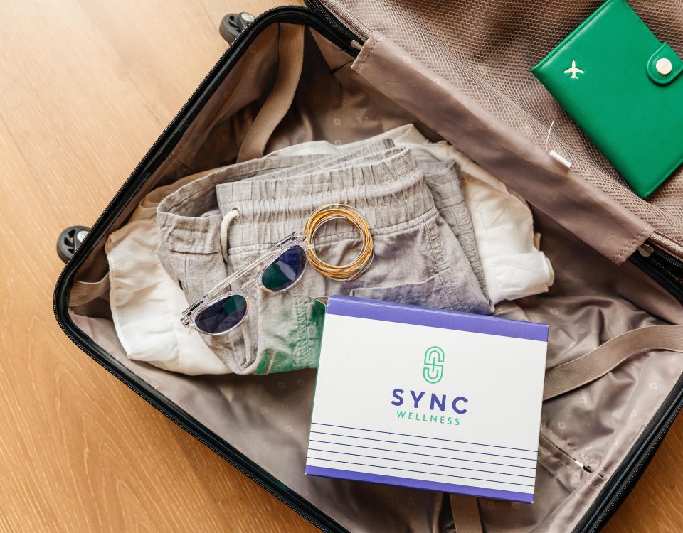 open, packed suitcase with sunglasses, clothes and sync pack box, Buy Supplements Online in Baton Rouge for Easy At-Home Wellness