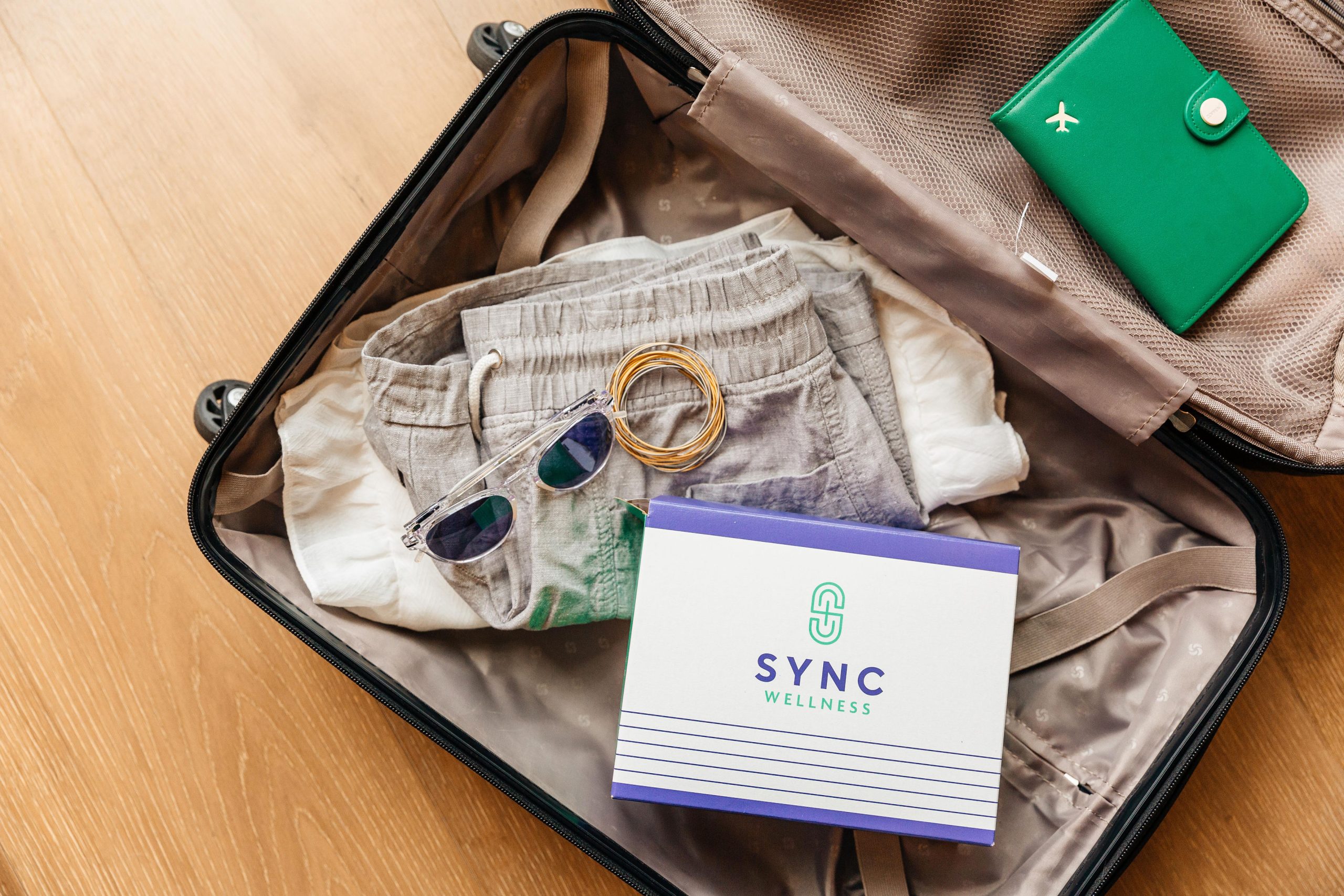 open, packed suitcase with sunglasses, clothes and sync pack box, Buy Supplements Online in Baton Rouge for Easy At-Home Wellness